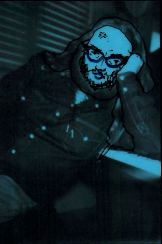 Hand holding a round mirror with a skull design in a dark setting
